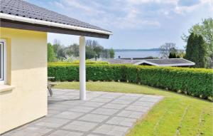a patio in front of a house with a hedge at Cozy Home In Egernsund With Kitchen in Egernsund