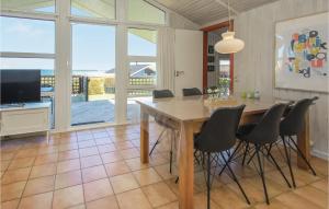 HejlsにあるAmazing Home In Sjlund With Saunaのダイニングルーム(テーブル、椅子、テレビ付)