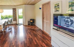 a living room with a flat screen tv and a dining table at Cozy Home In Egernsund With Kitchen in Egernsund