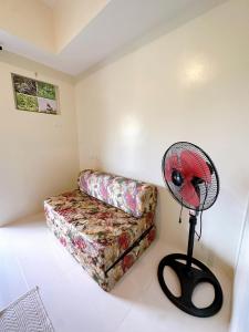 a fan in a room with a couch and a fan at Luxury Suites at Brenthill Baguio City in Baguio