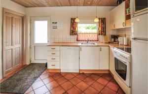 cocina con armarios blancos y suelo de baldosa en Cozy Home In Egernsund With Kitchen, en Egernsund