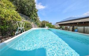 a swimming pool with a chair in the water at Nice Apartment In Rogno With Outdoor Swimming Pool, Wifi And 1 Bedrooms in Rogno