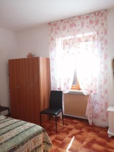- une chambre avec un lit, une chaise et une fenêtre dans l'établissement Il Casaletto, à Acquasparta