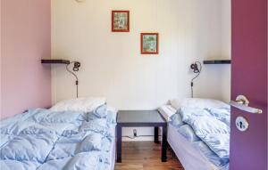 1 dormitorio con 2 camas y escritorio con mesa en 2 Bedroom Gorgeous Home In Fars en Hvalpsund