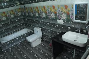 uma casa de banho com um WC branco e um lavatório. em JOYstels Kasol em Kasol