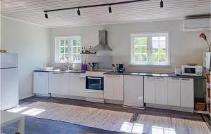 cocina grande con armarios blancos y electrodomésticos blancos en Nice Home In Hishult With Wifi, en Hishult