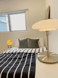 a bedroom with a bed and a lamp at A Private Room With Private Bathroom & Private Entrance,15 mins to KLIA, KLIA2, Sepang- Host By Private Locals Resident, Provide Paid Airport Transport Service, Downstairs Eatery & MCD, Petrol Station, ATM, 7-11 in Kampong Bekoh +13 photos