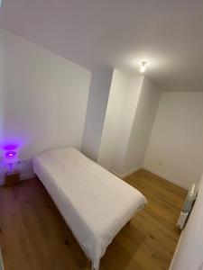 - une petite chambre avec un lit blanc dans l'établissement Super cozy appartement, à Marquette-lès-Lille