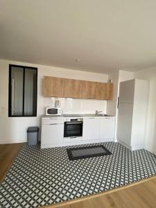 kuchnia z białymi szafkami oraz czarno-białą podłogą w obiekcie Super cozy appartement w mieście Marquette-lès-Lille