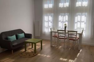 a living room with a table and chairs and a couch at Super cozy appartement in Marquette-lès-Lille +1 photo