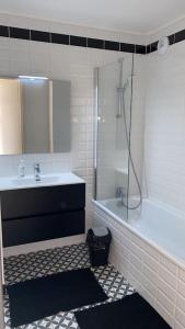 W łazience znajduje się wanna, umywalka i prysznic. w obiekcie Super cozy appartement w mieście Marquette-lès-Lille