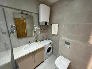 y baño con lavabo y lavadora. en Apartments Lux sea view en Budva