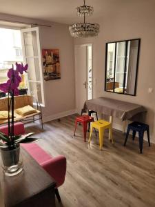 een woonkamer met kleurrijke stoelen en een tafel bij Appartement entier - Paris 12 in Parijs