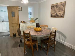 una mesa de comedor con sillas y un bol de fruta. en Windsor Cottage: Cosy, Charming, Full of Character, en Windsor