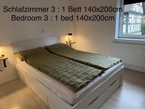 a large bed in a bedroom with avertisement for at Diah's Apartment in BEUERN - für Monteure in Felsberg