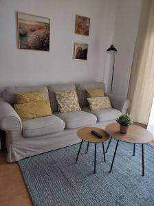 sala de estar con sofá y 2 mesas en Apartamento Puerto Chico en El Puerto de Santa María