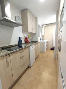 a large kitchen with white cabinets and a tile floor at Apartamento Puerto Chico in El Puerto de Santa María