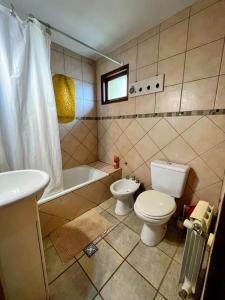 uma casa de banho com um WC, uma banheira e um lavatório. em Calida cabaña em Ushuaia