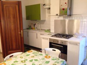 cocina con fogones, mesa y 2 sillas en Casa Farinati 2 en Verona