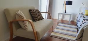 a living room with a chair and a bed at A-Típica GuestHouse in Ponta Delgada