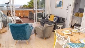 a living room with a couch and a table and chairs at Plover 2 - The Cove in Brixham