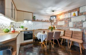 eine Küche mit einem Tisch, Stühlen und einer Ziegelwand in der Unterkunft Pet Friendly Home In Radovan With Sauna 
