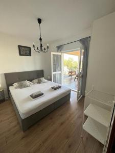 Un dormitorio con una cama grande y una lámpara de araña. en Apartmani Sladić, en Betina 89 fotos más