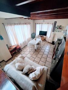 ein Wohnzimmer mit einem Bett und einem Tisch in der Unterkunft Calida cabaña in Ushuaia