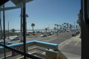 een raam met uitzicht op een straat met palmbomen bij Huntington Surf Inn in Huntington Beach