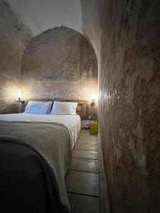 a bedroom with a large bed in a stone wall at Latmos 1860 in Skala