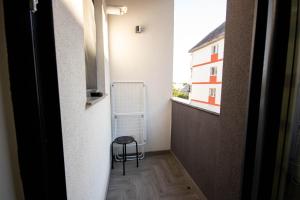 un petit couloir avec une chaise et une fenêtre dans l'établissement AStar Apartments - LARGE, à Rădăuţi