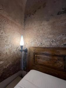 a bedroom with a bed with a light on the wall at Latmos 1860 in Skala