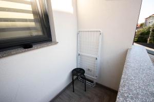 a stool in a corner of a room with a window at AStar Apartments - LARGE in Rădăuţi