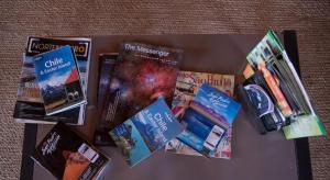 a table topped with books and magazines on a table at Hostal Katarpe in San Pedro de Atacama