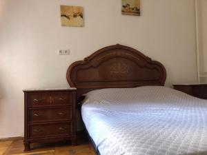 1 dormitorio con cama de madera y vestidor en Comfortable apartments near Gulliver, en Kiev