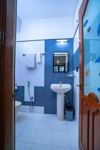 a blue and white bathroom with a sink and a toilet at SS Mystic Apartotel in Bangalore