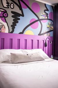 1 dormitorio con 1 cama con una pintura en la pared en hotel velero cavancha en Iquique