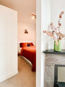 een slaapkamer met een bed en een vaas met bloemen bij Anna Boutique Apartments in Nijmegen