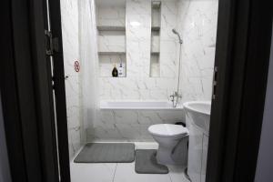 a bathroom with a toilet and a tub and a sink at AStar Apartments - LARGE in Rădăuţi +22 photos