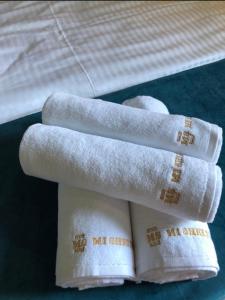 stos ręczników na łóżku z książką w obiekcie MiShelter w mieście Migowo