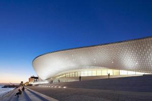 a building with a white facade next to the ocean at Vintage Sailboat in Belém in Lisbon