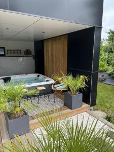 a patio with a pool table and potted plants at Villa H ste Marine in Combrit