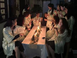 um grupo de mulheres sentadas à volta de uma mesa com velas em GIFTLAND HOMESTAY em Āīzawl