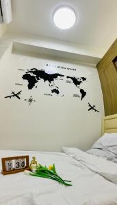1 dormitorio con un mapa del mundo en la pared en SPRING RESIDENCES - Bicutan by M&S en Manila