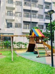 un parque infantil en un parque frente a un edificio en SPRING RESIDENCES - Bicutan by M&S en Manila