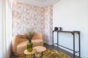 ein Wohnzimmer mit einem Stuhl und einem Tisch in der Unterkunft Hotel Stad aan Zee Vlissingen in Vlissingen