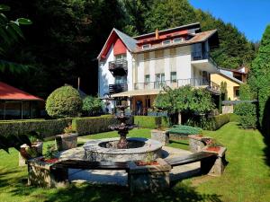 a large house with a fountain in front of a yard at Villa Onix in Sinaia