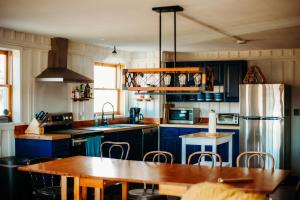 uma cozinha com armários azuis e uma mesa de madeira em The Barn at Evermore: riverfront retreat w/hot tub em Luray