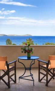 um pátio com uma mesa e cadeiras e o oceano em iliopetro em Monemvasia