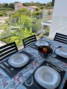 a table with plates and a bowl of fruit on it at Magic Kefalonia Villa in Spartia